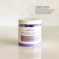 Aromatherapy bath bomb in a jar featuring the Lavender + Vanilla blend. A calming and soothing fragrance perfect for unwinding at the end of the day. Packaged in a sleek, minimalist jar with a soft purple label, designed for a relaxing and moisturizing bath experience.
