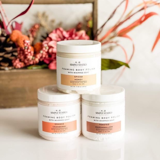 Simply Stated Fall Foaming Body Polish in Orange Cranberry, Spiced Honey, and Toasted Marshmallow with autumn decor