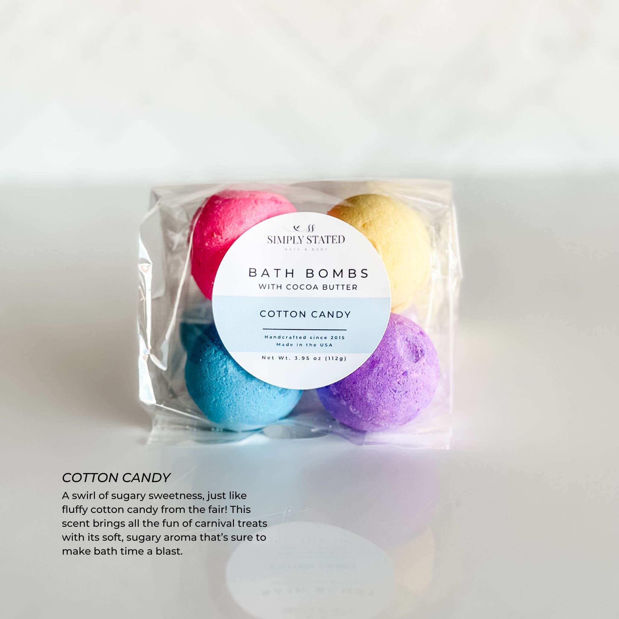 Simply Stated Kids Line Bath Bomb Pack in Cotton Candy scent, featuring colorful pink, blue, yellow, and purple bath bombs packaged in a clear bag with a circular label.