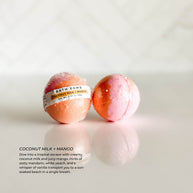 Individually wrapped Coconut Milk + Mango bath bomb from Simply Stated Bath & Body. A tropical blend of creamy coconut milk, juicy mango, mandarin, and vanilla for a sun-soaked bath experience.
