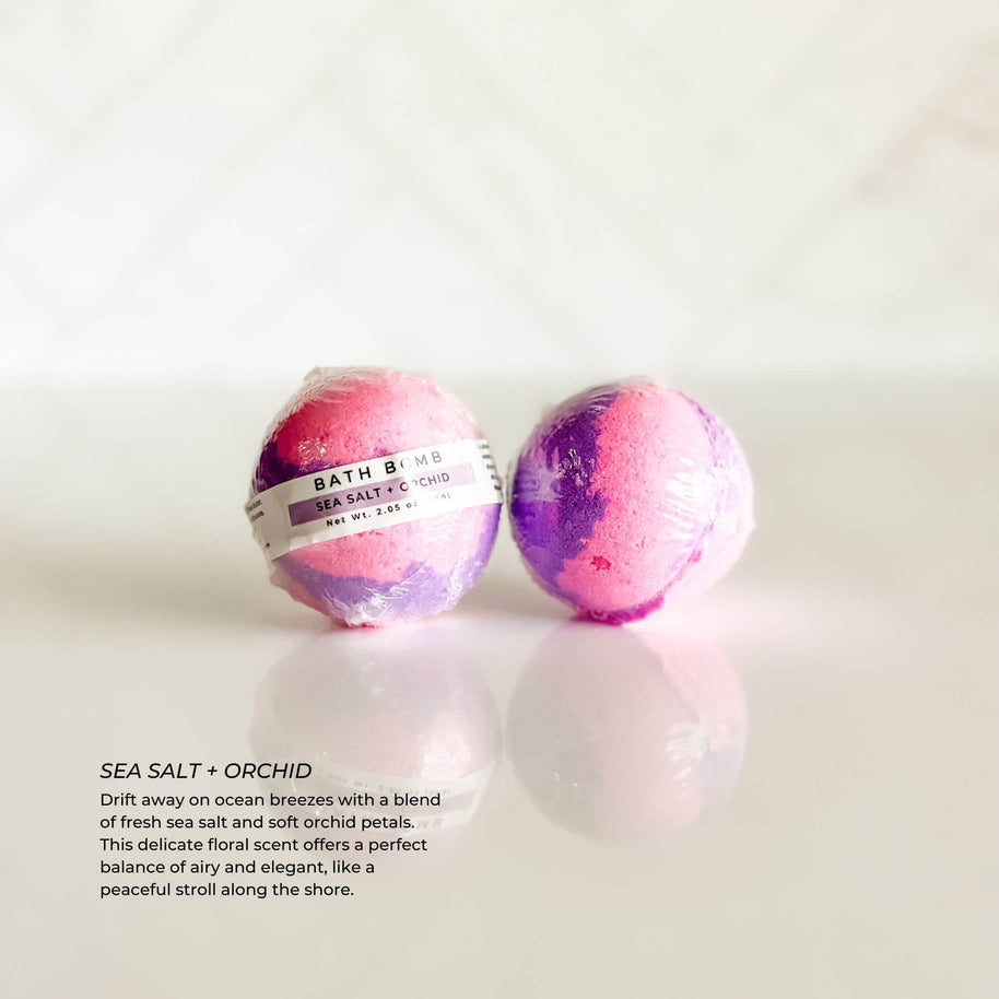 Individually wrapped Sea Salt + Orchid bath bomb from Simply Stated Bath & Body. A refreshing blend of ocean breeze, fresh sea salt, and delicate orchid petals for a coastal-inspired bath.
