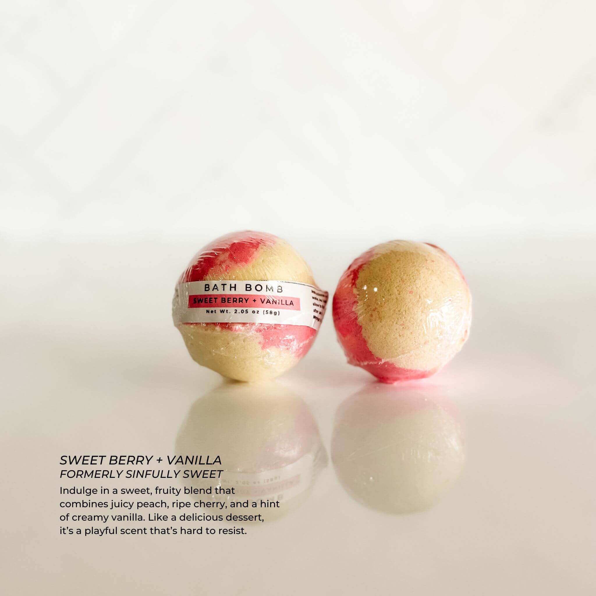Individually wrapped Sweet Berry + Vanilla bath bomb from Simply Stated Bath & Body. A fruity blend of ripe peach, cherry, and creamy vanilla for a playful and indulgent bath experience.
