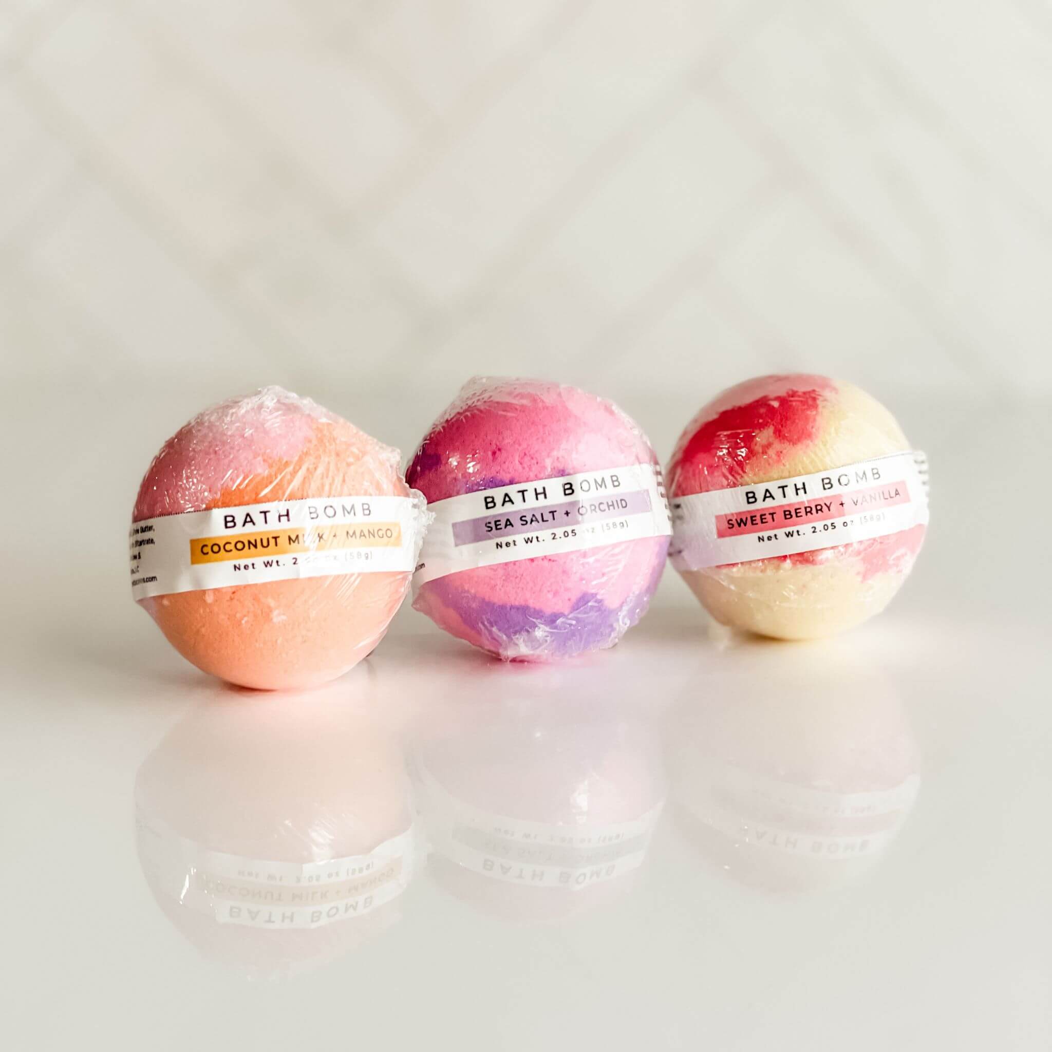 Set of three Signature Line bath bombs from Simply Stated Bath & Body featuring Coconut Milk + Mango, Sea Salt + Orchid, and Sweet Berry + Vanilla. A luxurious bath bomb trio designed for hydration, relaxation, and indulgence.
